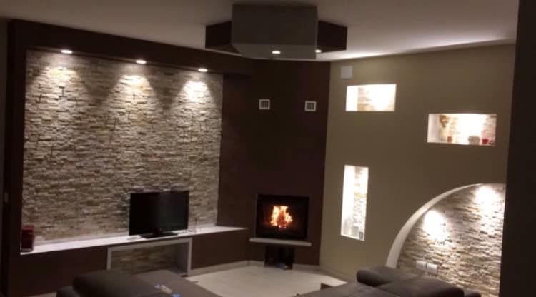 Sala moderna con decorazioni in cartongesso camino luce e pietra pregiata.